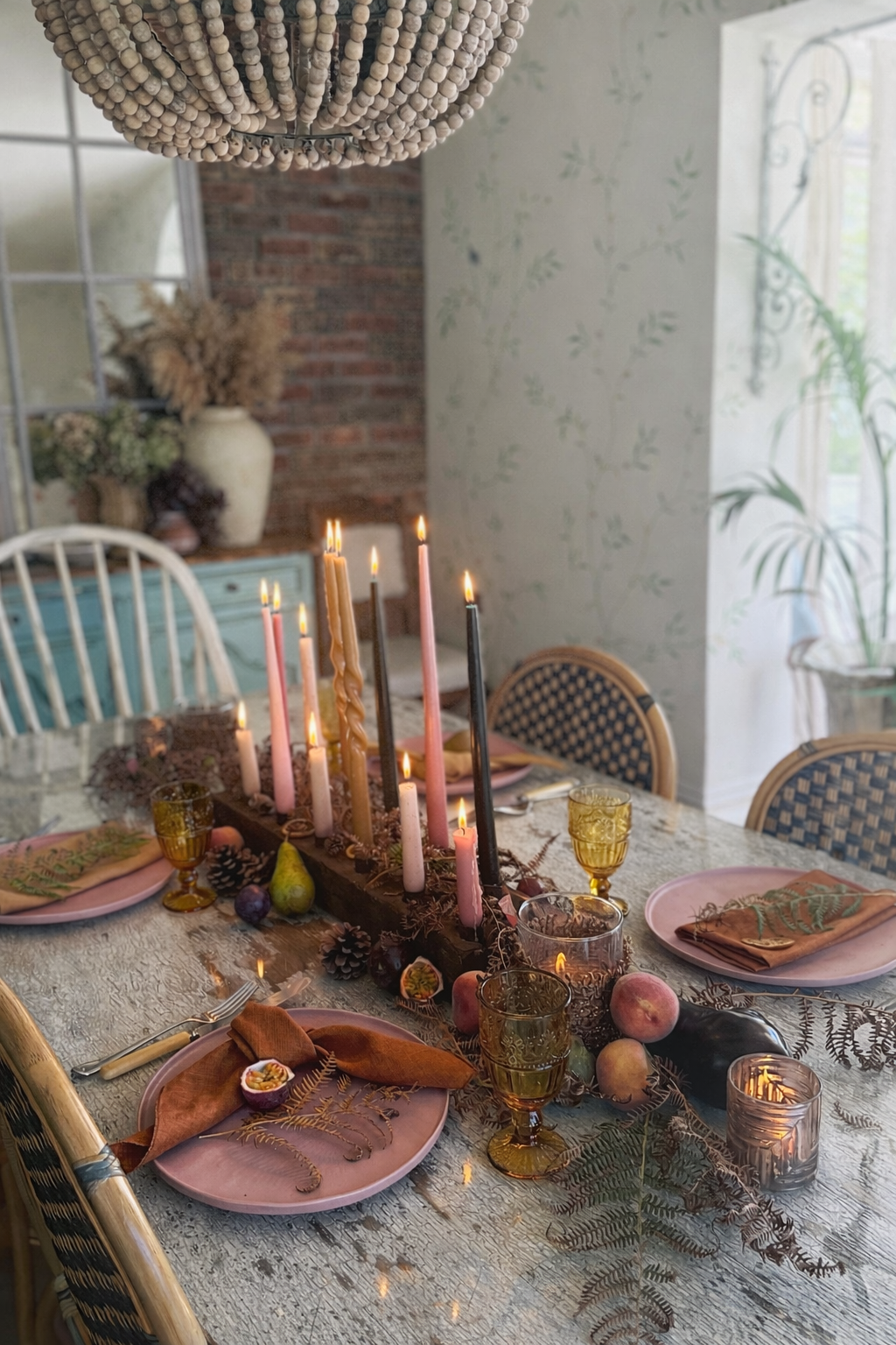 Dining table set for a meal with candles, plates, and decorative items.