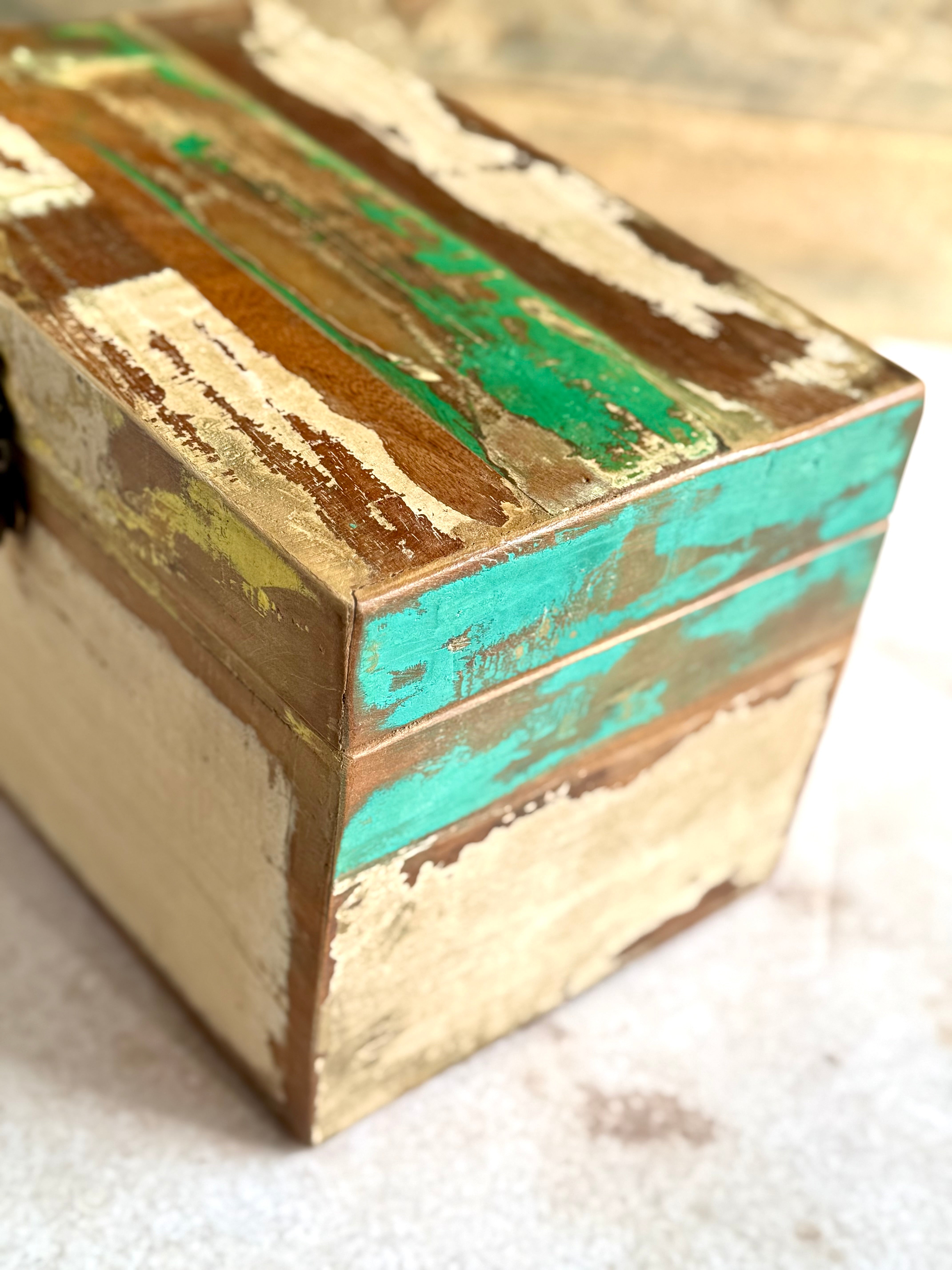Close up detail shot of reclaimed teak wood storage box in green, turquoise, yellow and cream tones