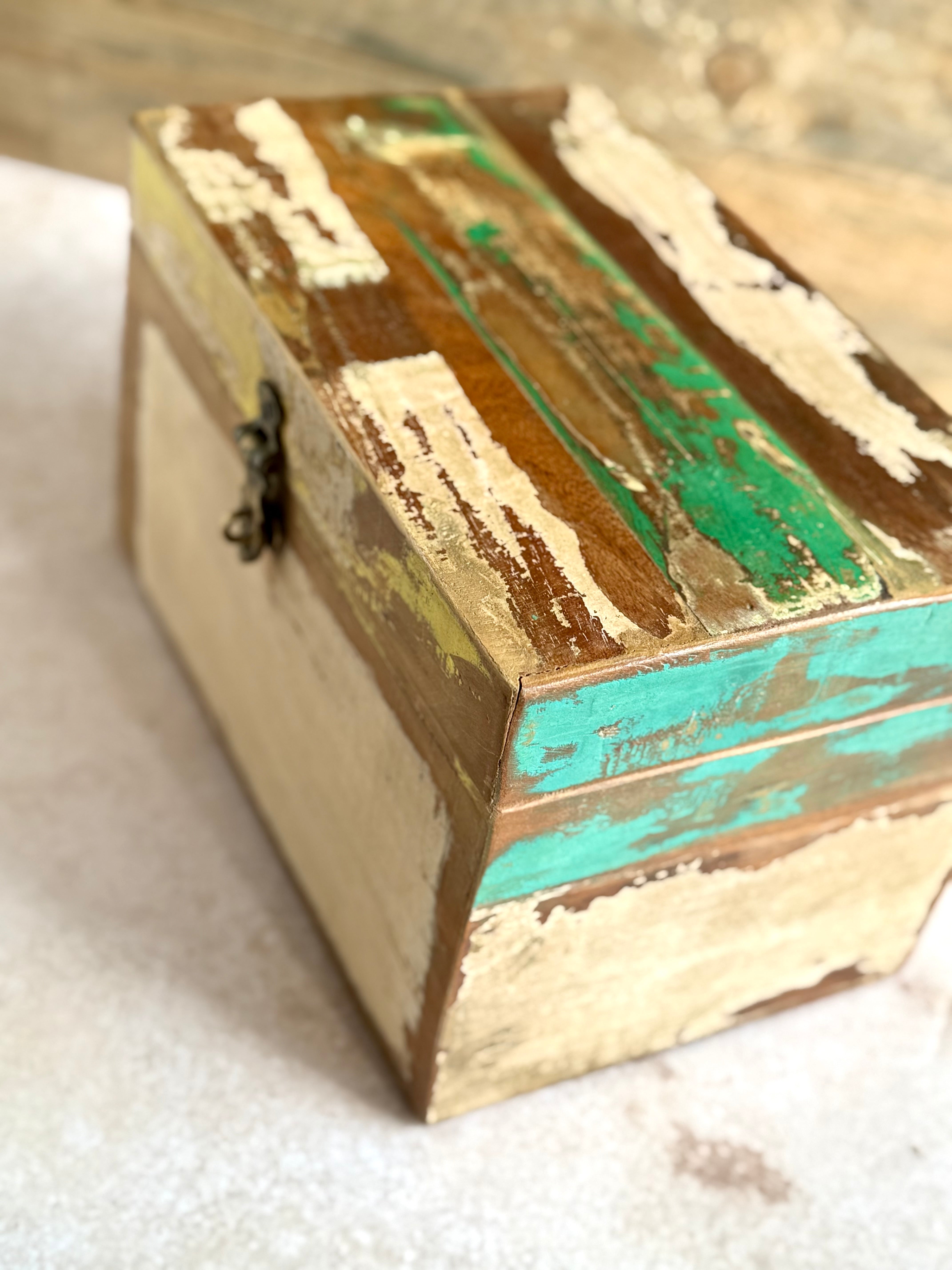 Close up detail shot of reclaimed teak wood storage box in green, turquoise, yellow and cream tones