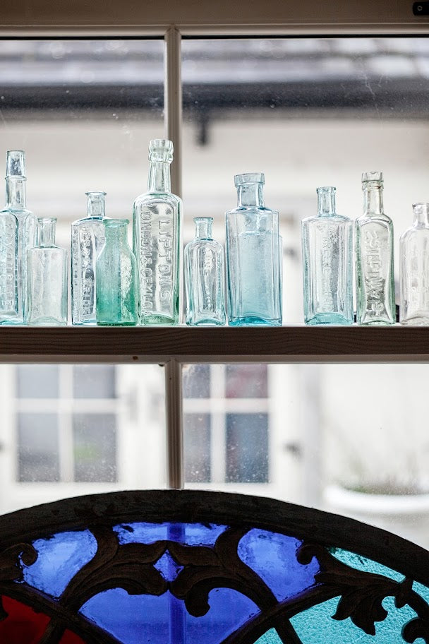 Collection of glass bottles on a shelf with a blurred background