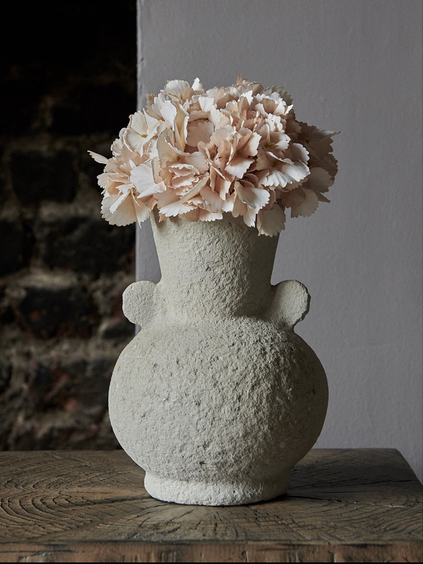 Textured cream vase with peach hydrangea in moody room