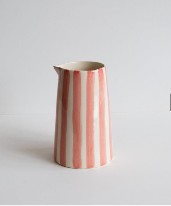 Pink and white striped pitcher with no handle on light backgorund