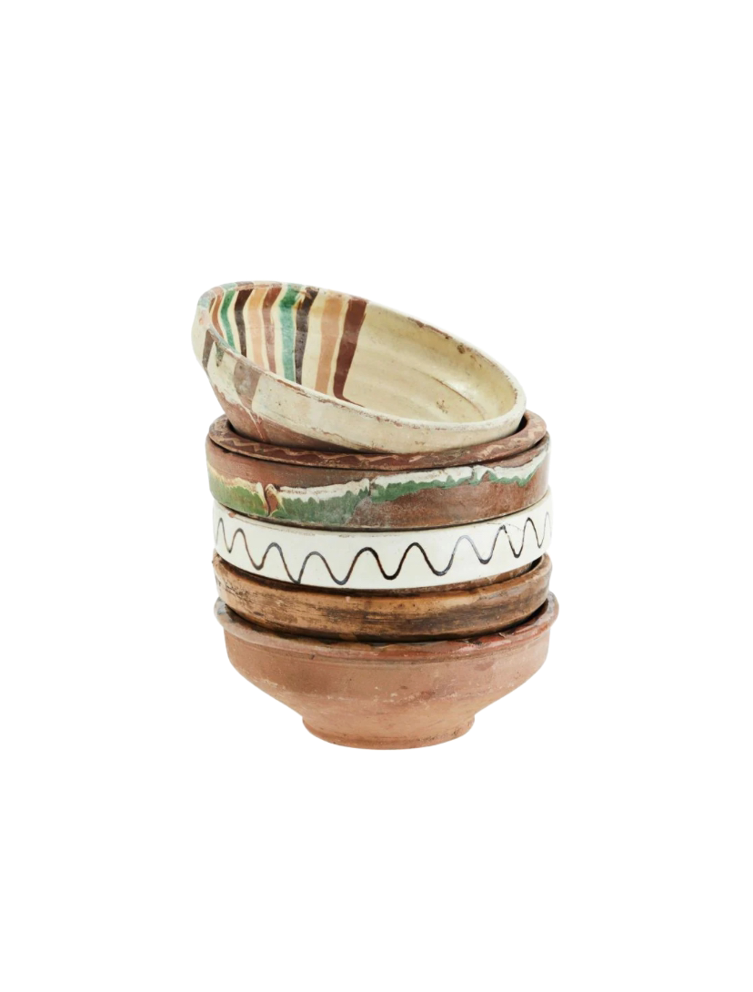 A stack of vintage earthenware bowls with hand-painted designs and a patina finish.