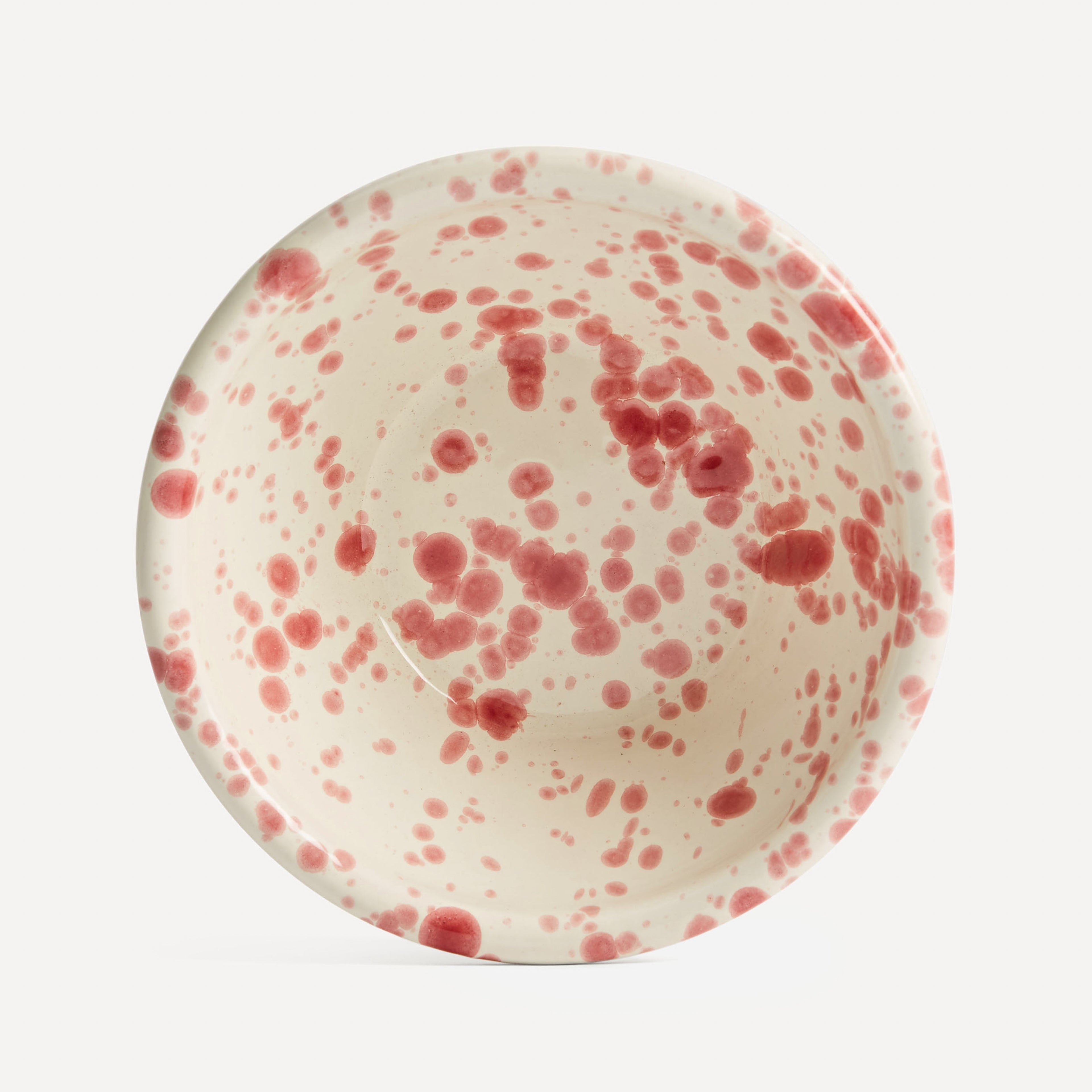 A small ceramic bowl with a green splatter paint finish on a white background.