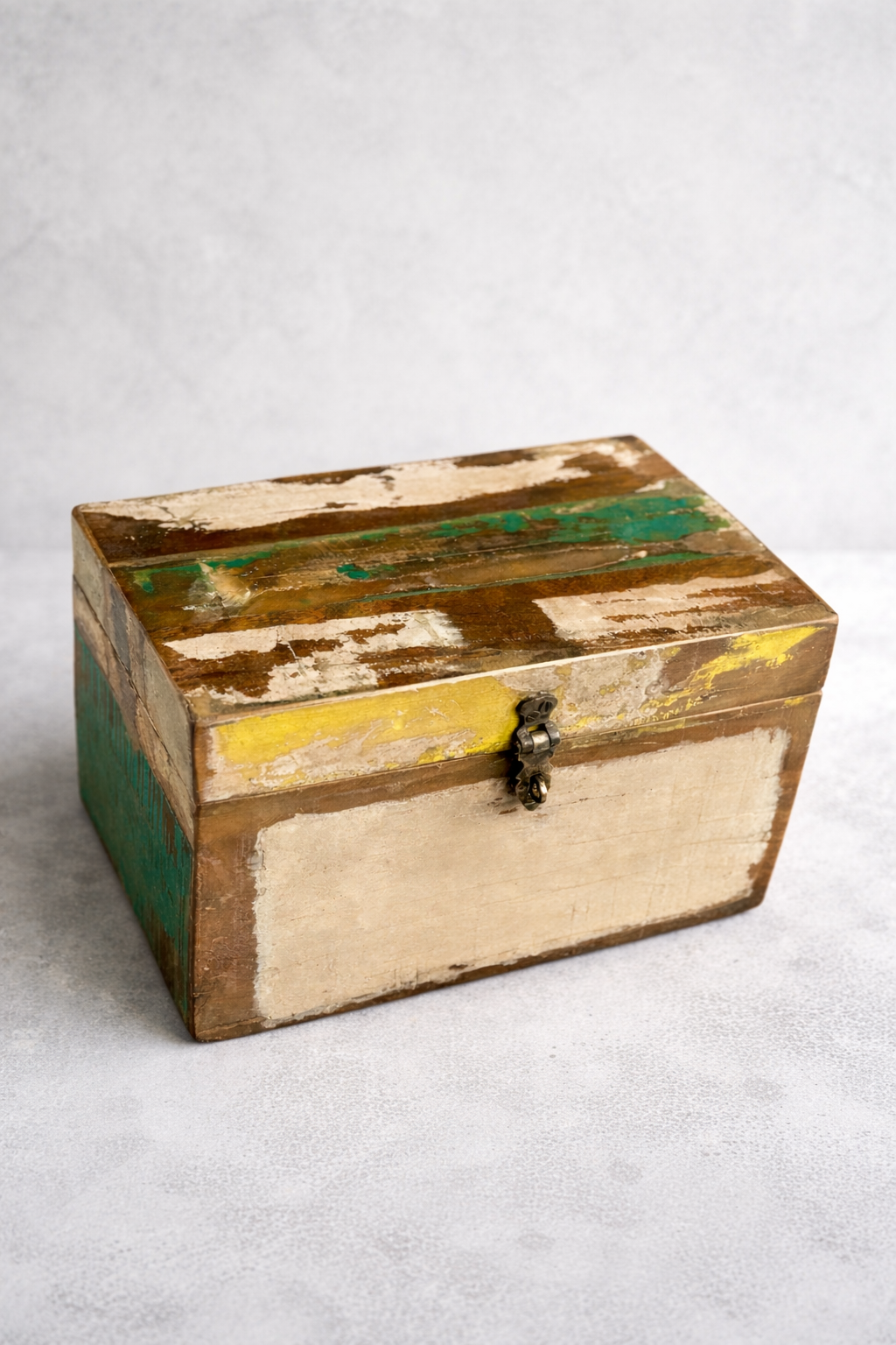 Reclaimed wood storage box with green yellow and beige accents on grey background