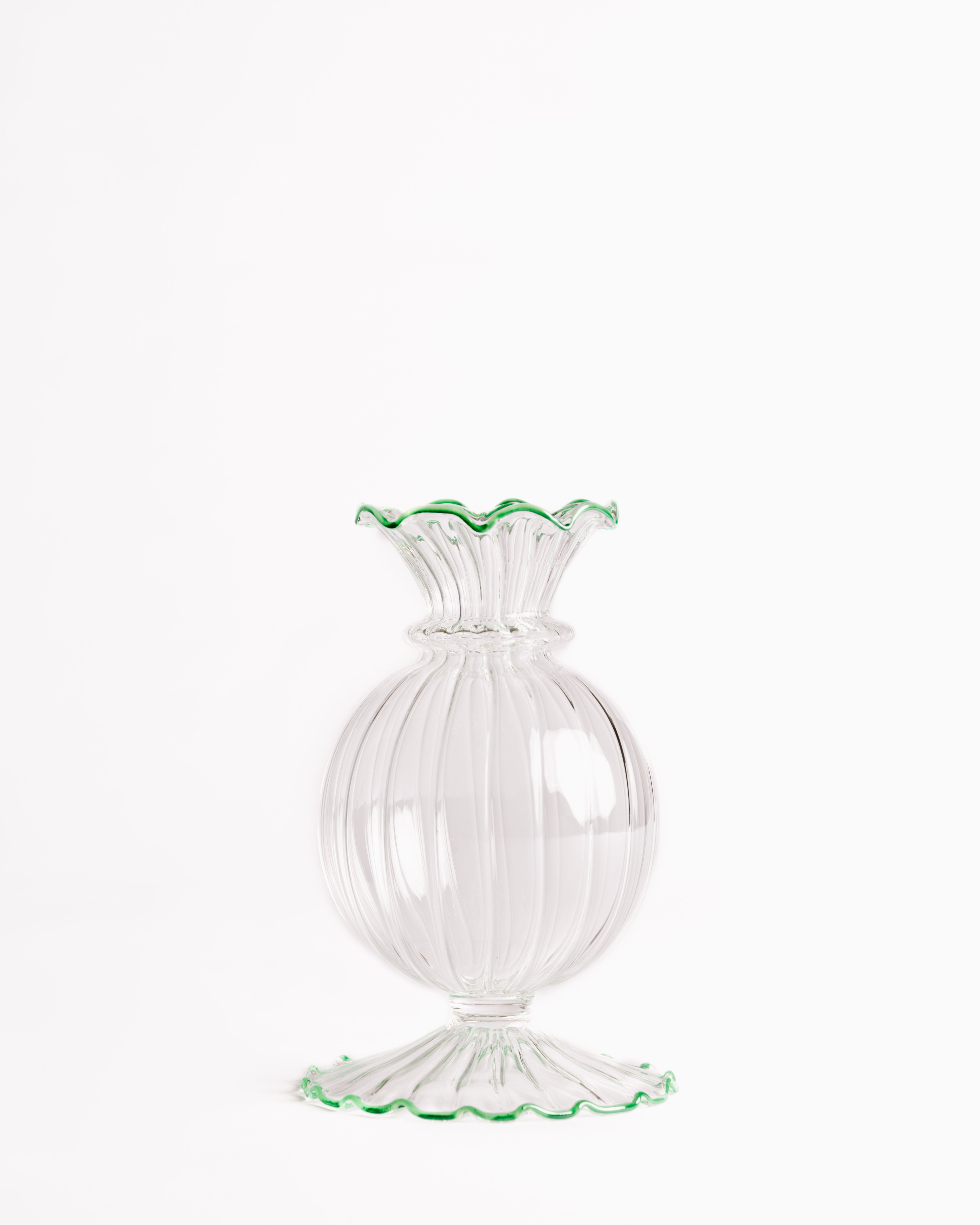 A clear glass bud vase with a frilly edge design, featuring a swirling pattern and a green rim at the top.