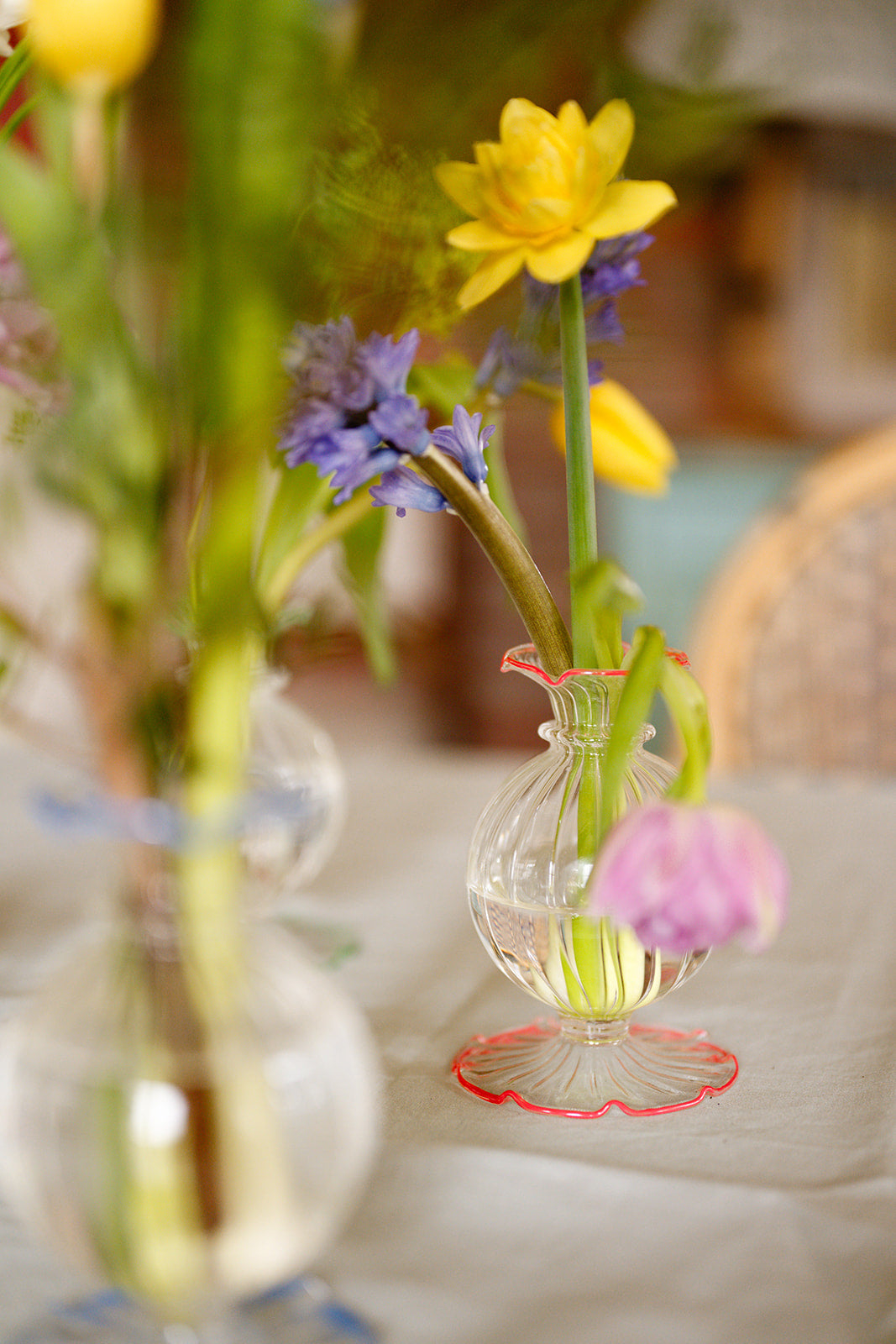 Small glass vase with flowers on a blurred background