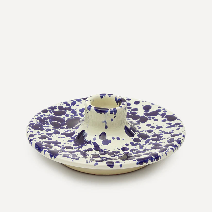 A ceramic candle holder with a blue and white splatter pattern.