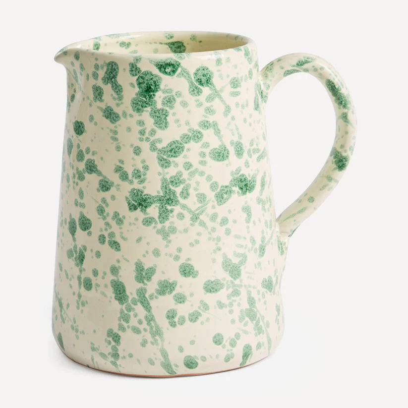 A ceramic splatter jug with a green and white floral pattern