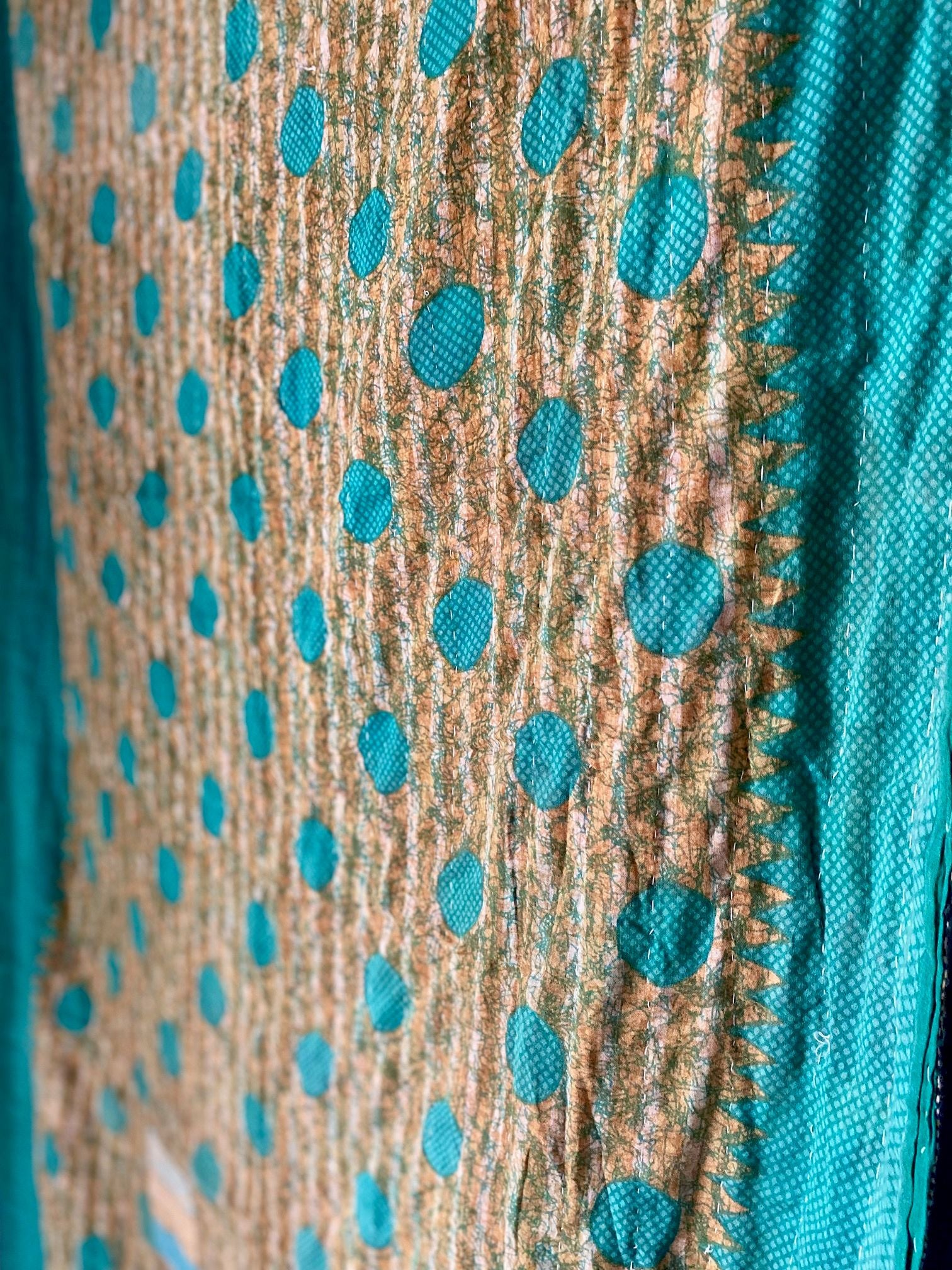 Close-up of a fabric with turquoise polka dots on a textured brown background
