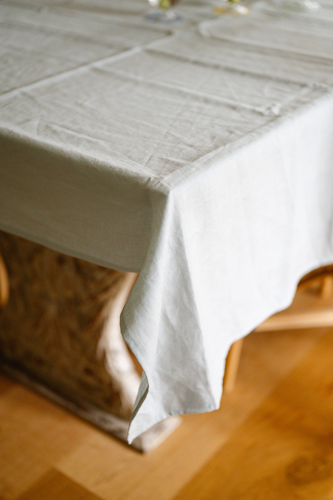 Close up shot of a duck egg blue tablecloth draped over old wood table
