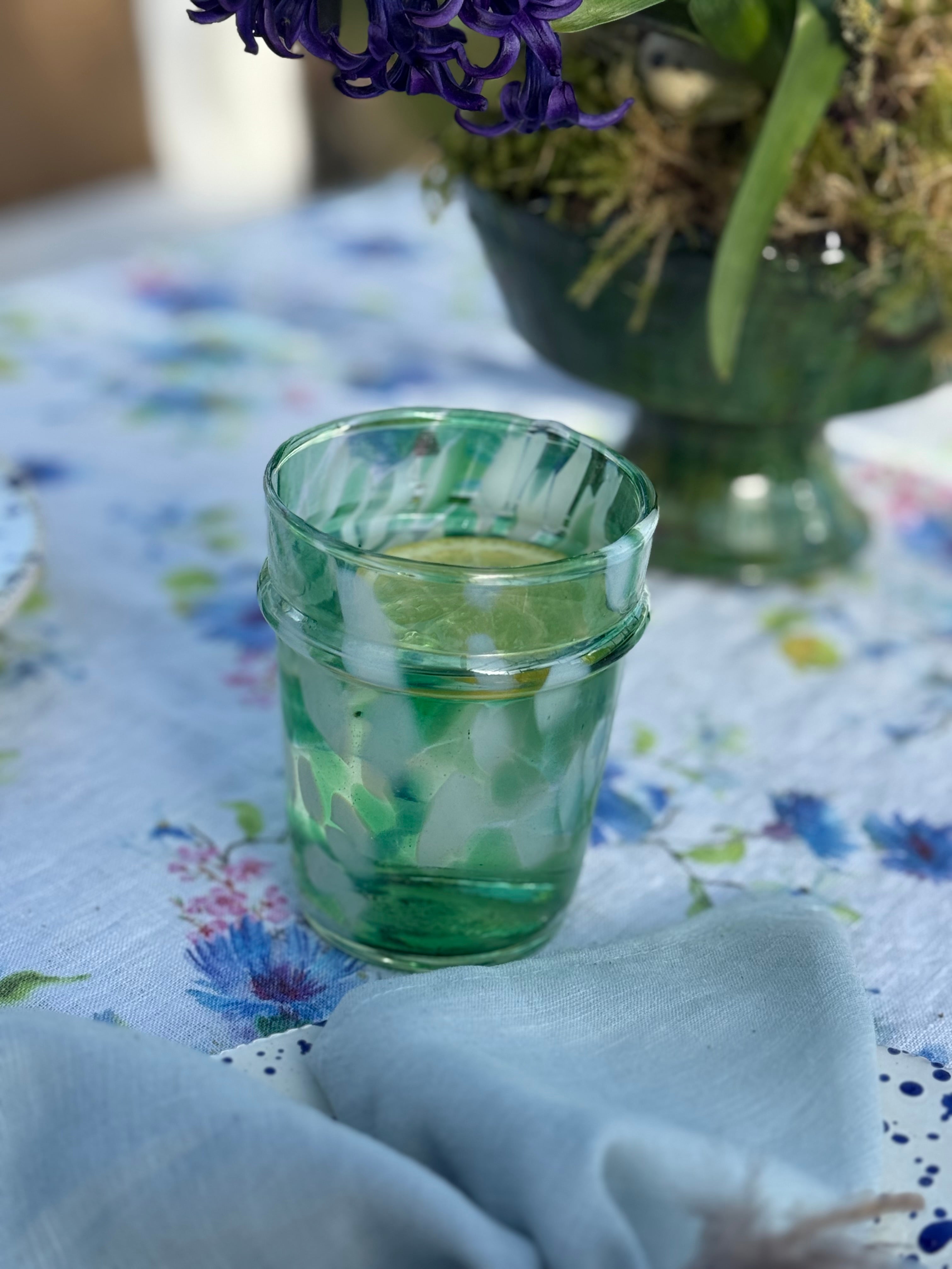 drinking glass with green and white splatter design