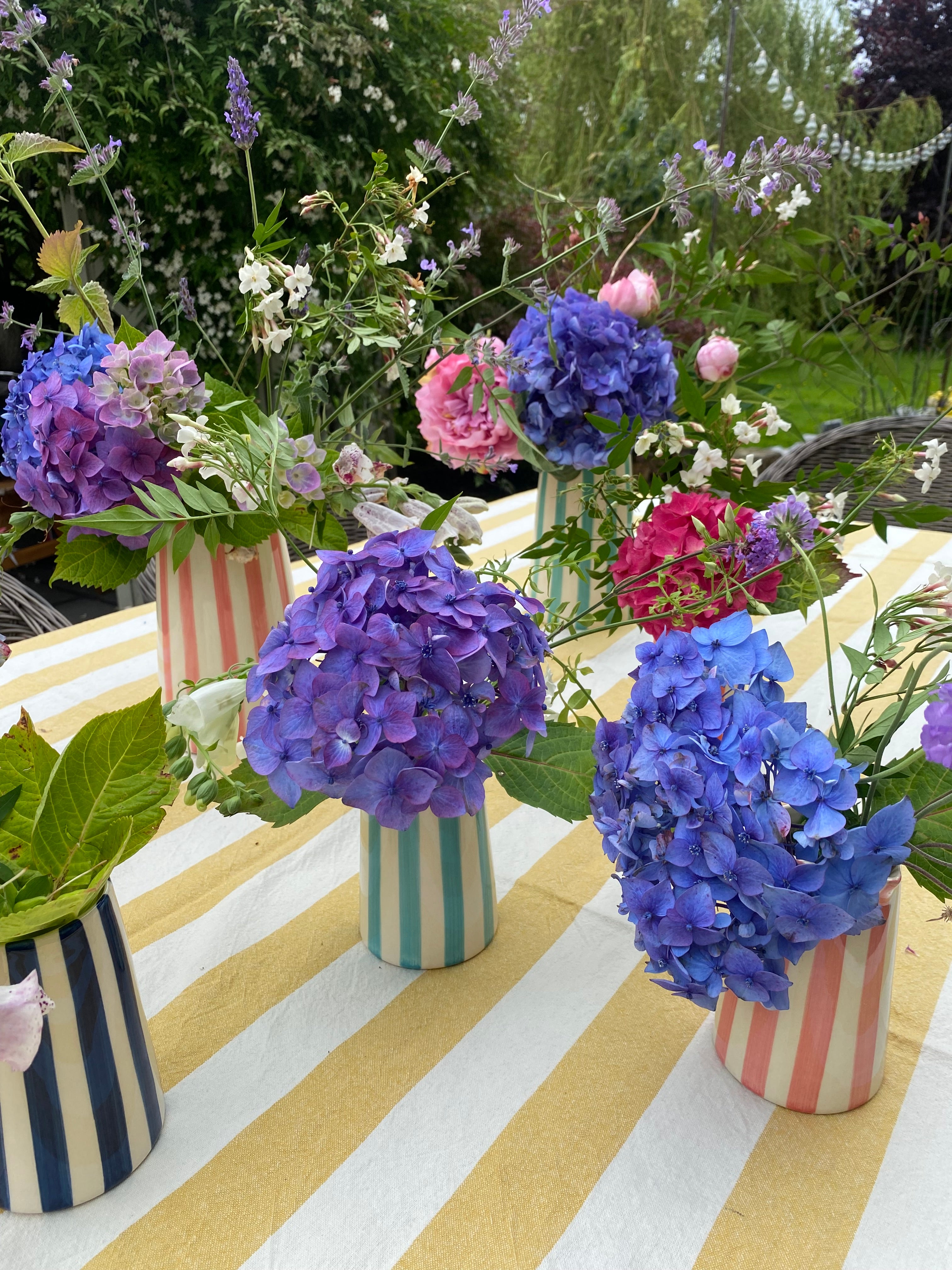 Mint striped jug styled outdoors among other striped jugs