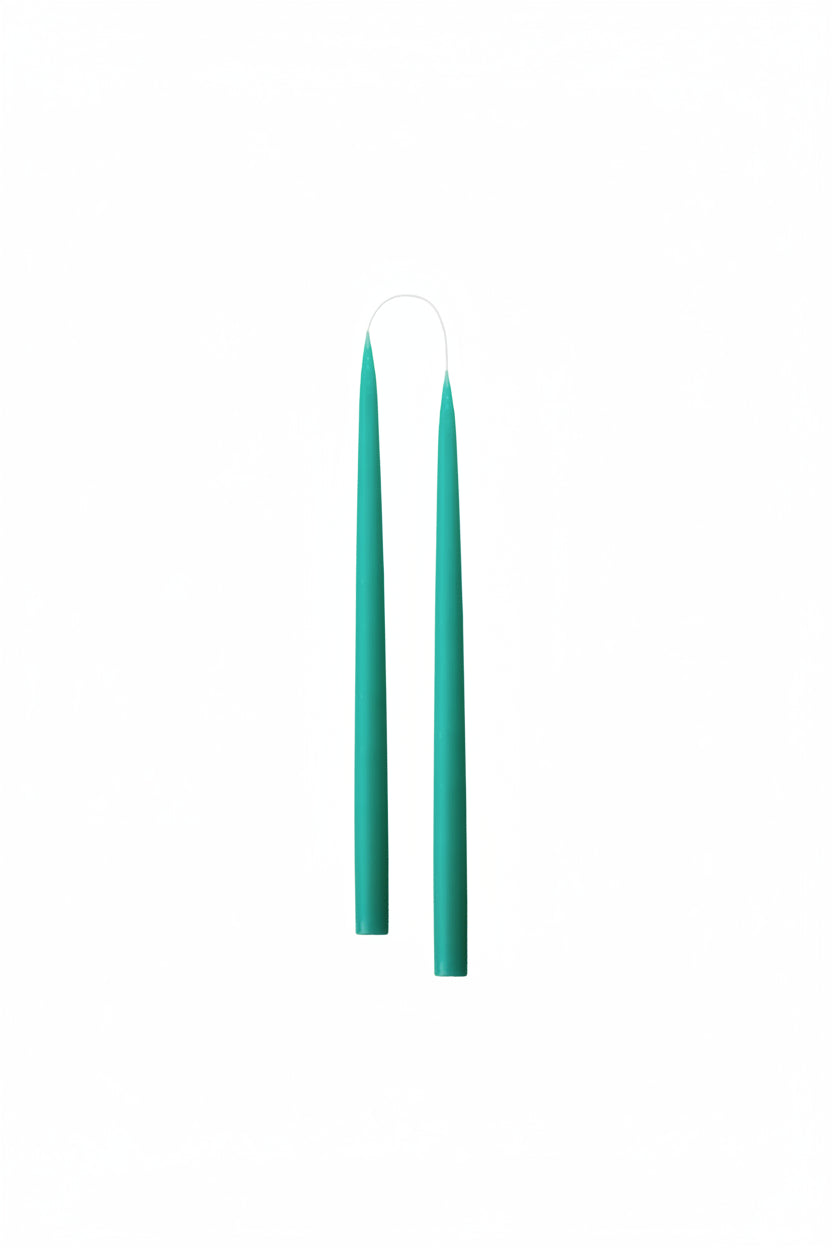 tapered turquoise candles against white background