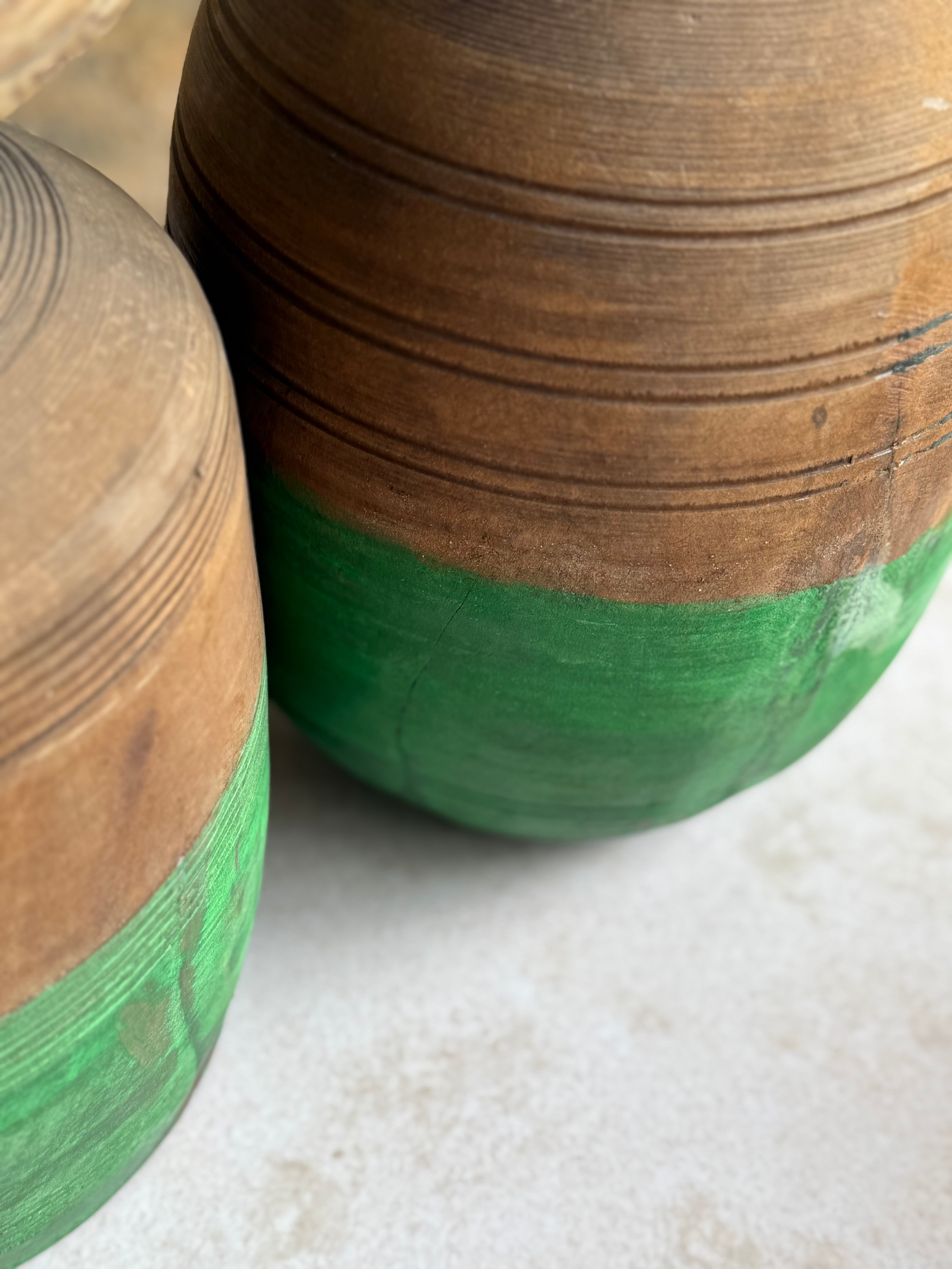 Two wooden containers with green bases on a white surface.