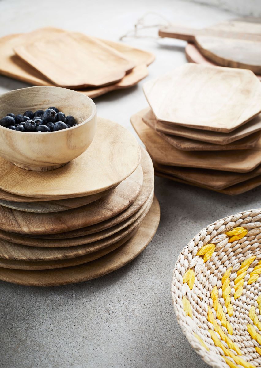 Stacks of wooden bowls and plates on slate background