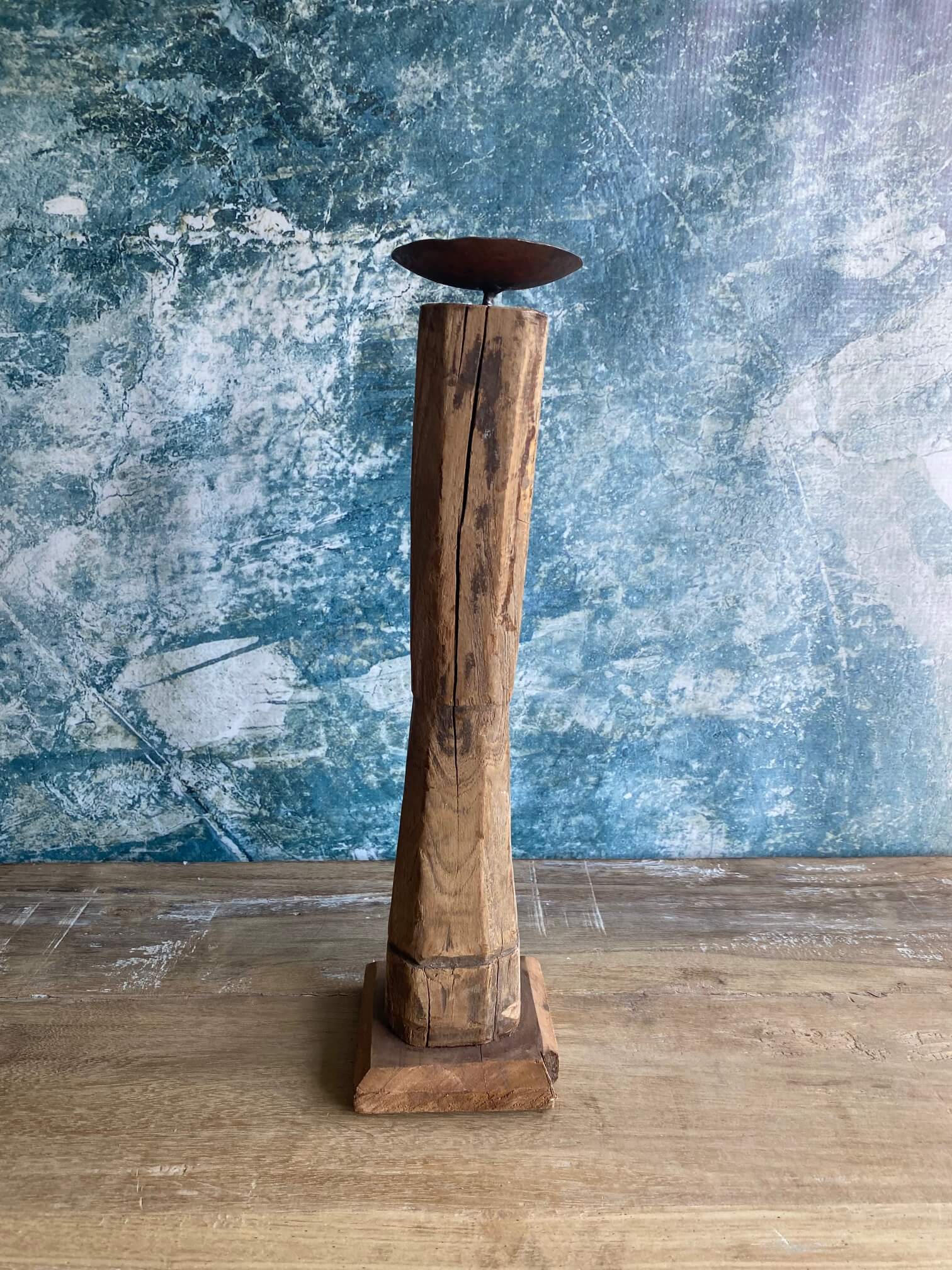Reclaimed wood candle stick against blue textured background