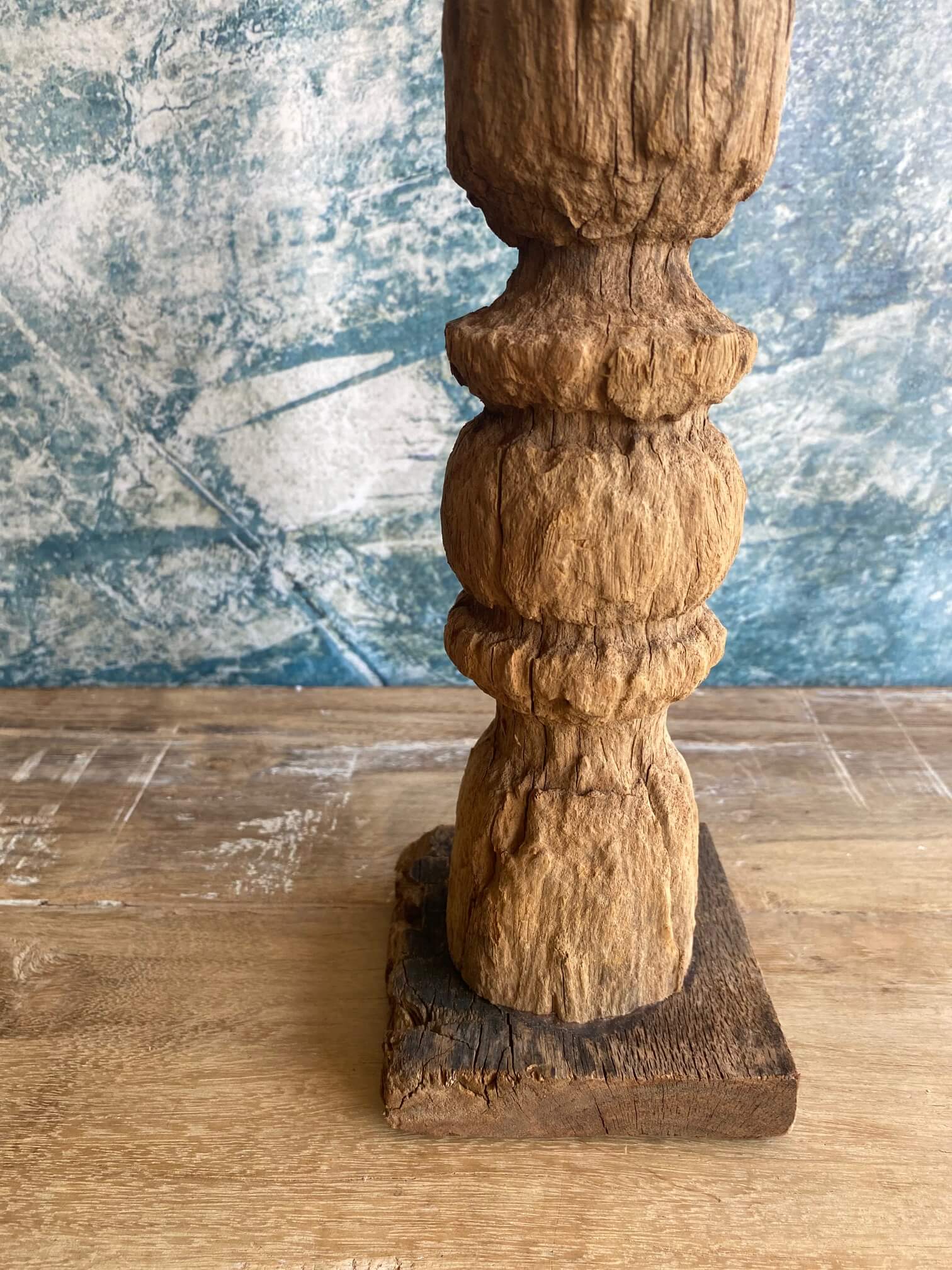 Close up of reclaimed wood candle stick against blue textured background