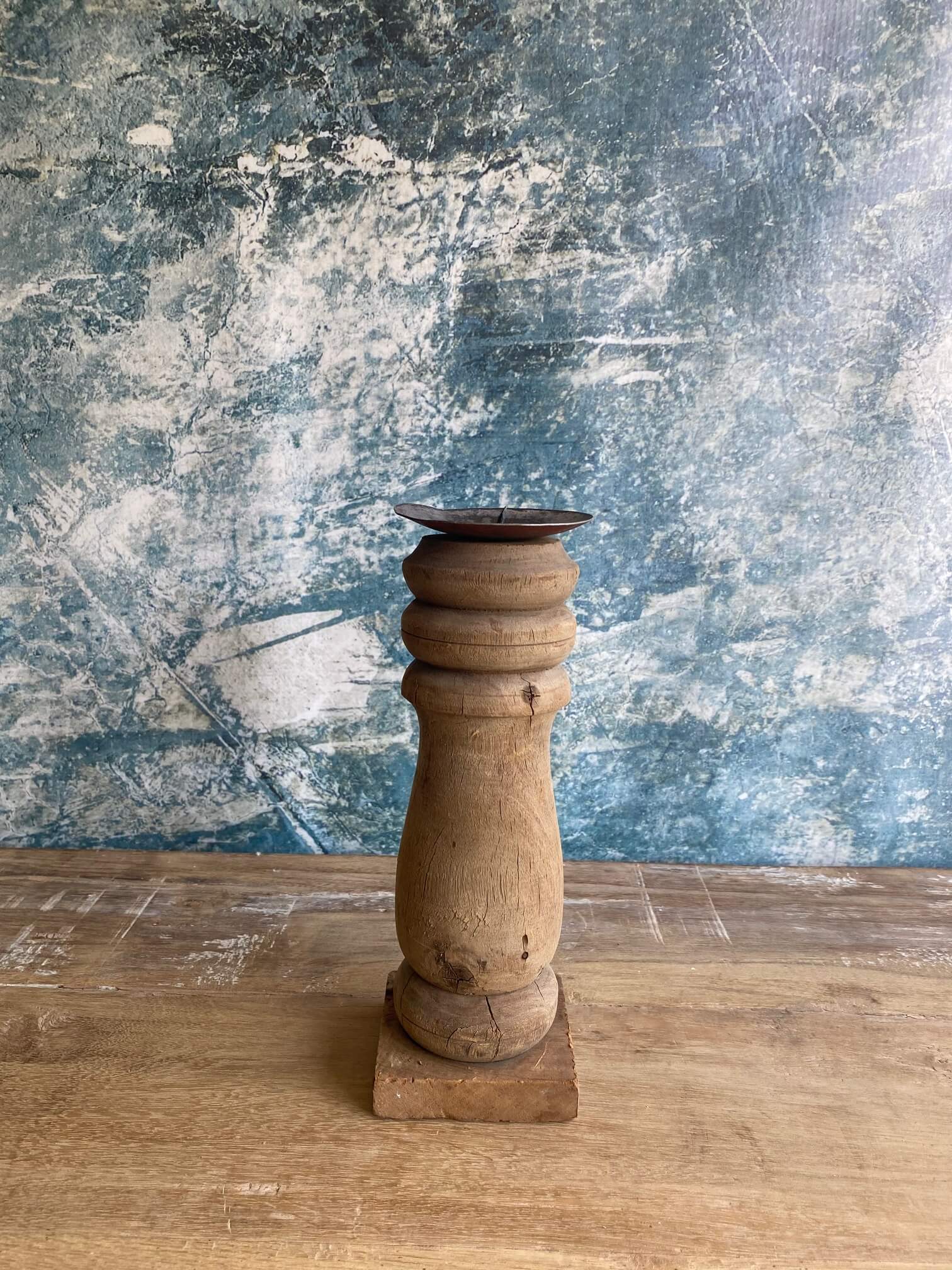 reclaimed wood candle stick against blue textured background