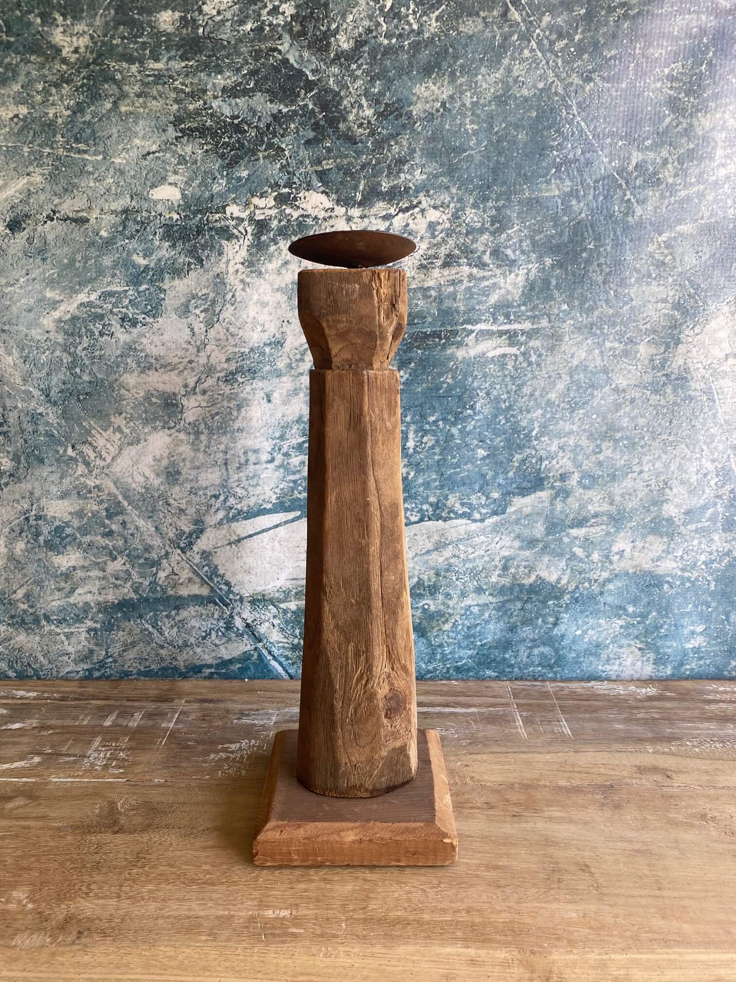 reclaimed wood candle stick against blue textured background