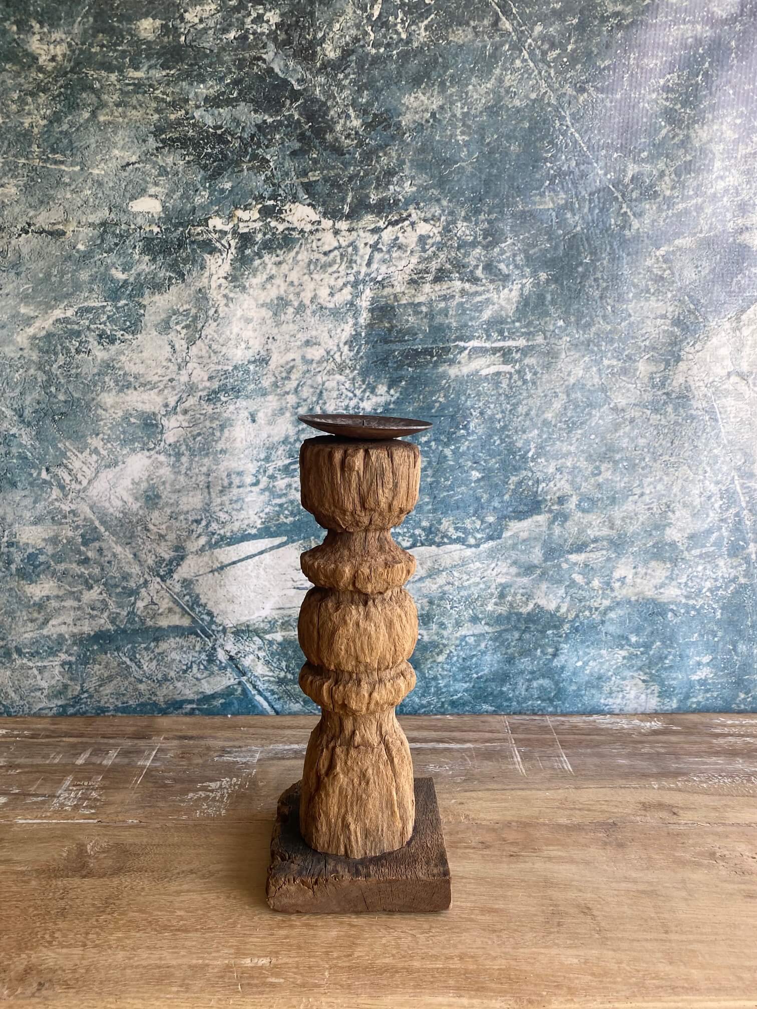Reclaimed wood candle stick against blue textured background