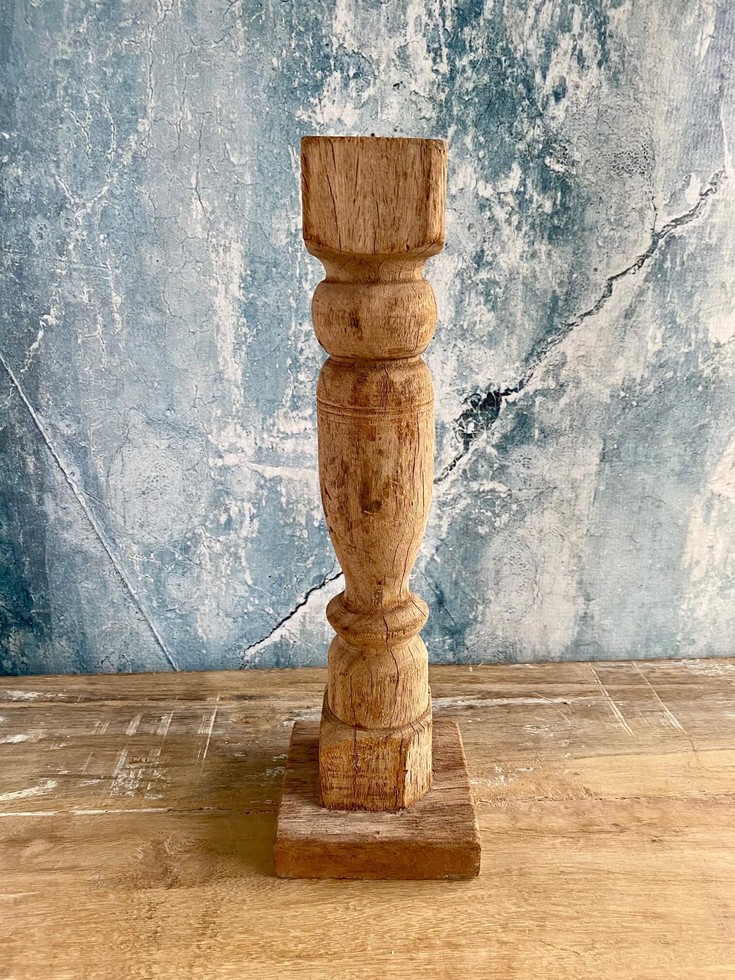 reclaimed wood candle stick against blue textured background