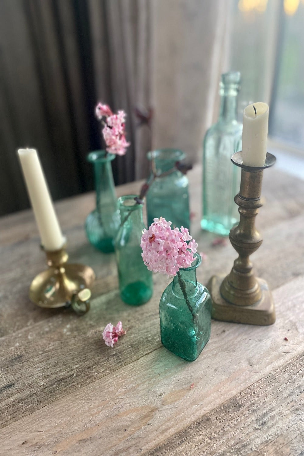 Vintage turquoise vases on rustic table with tarnished brass candlesticks