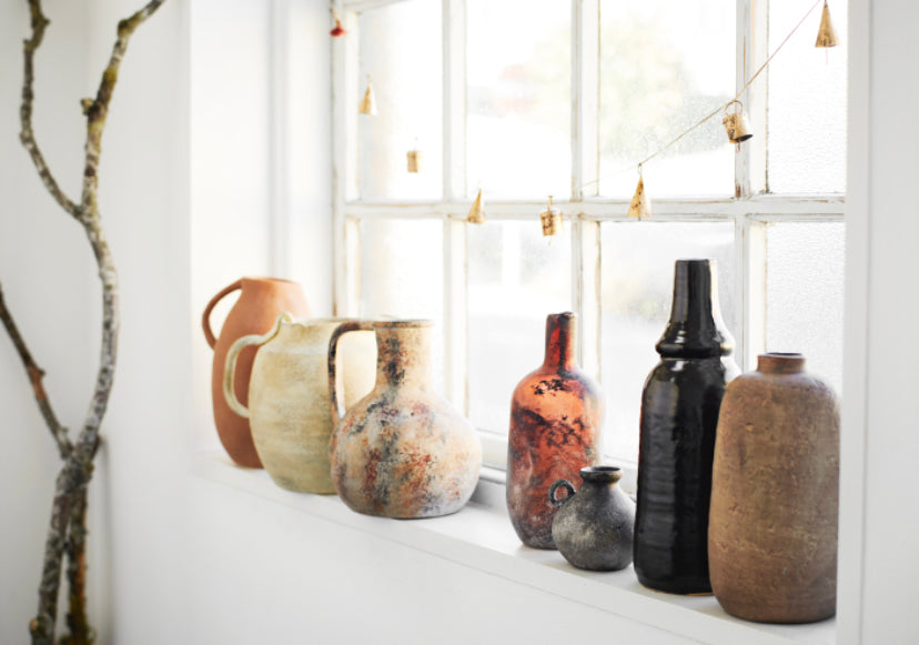 Collection of vases on window sill in didfferent textures and colours