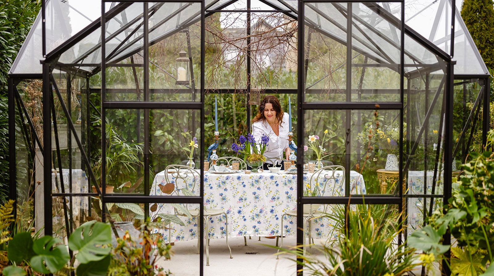 Stylish glasshouse table setting with a stonewashed floral tablecloth, created by Irish interior designer Amber of Amber + Willow