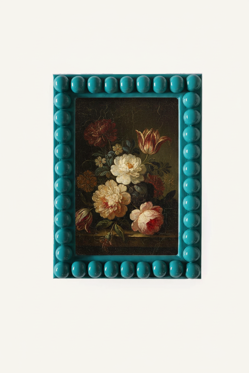 A teal lacquered bobbin framed still life painting featuring a bouquet of flowers, surrounded by a glossy turquoise frame with a beaded border, set against a plain off-white background.