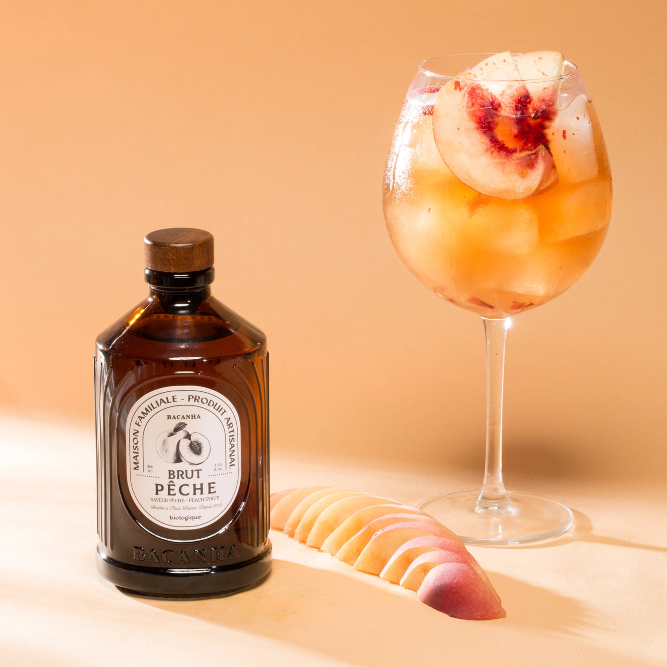 Bottle of artisan peach puree next to a peach cocktail