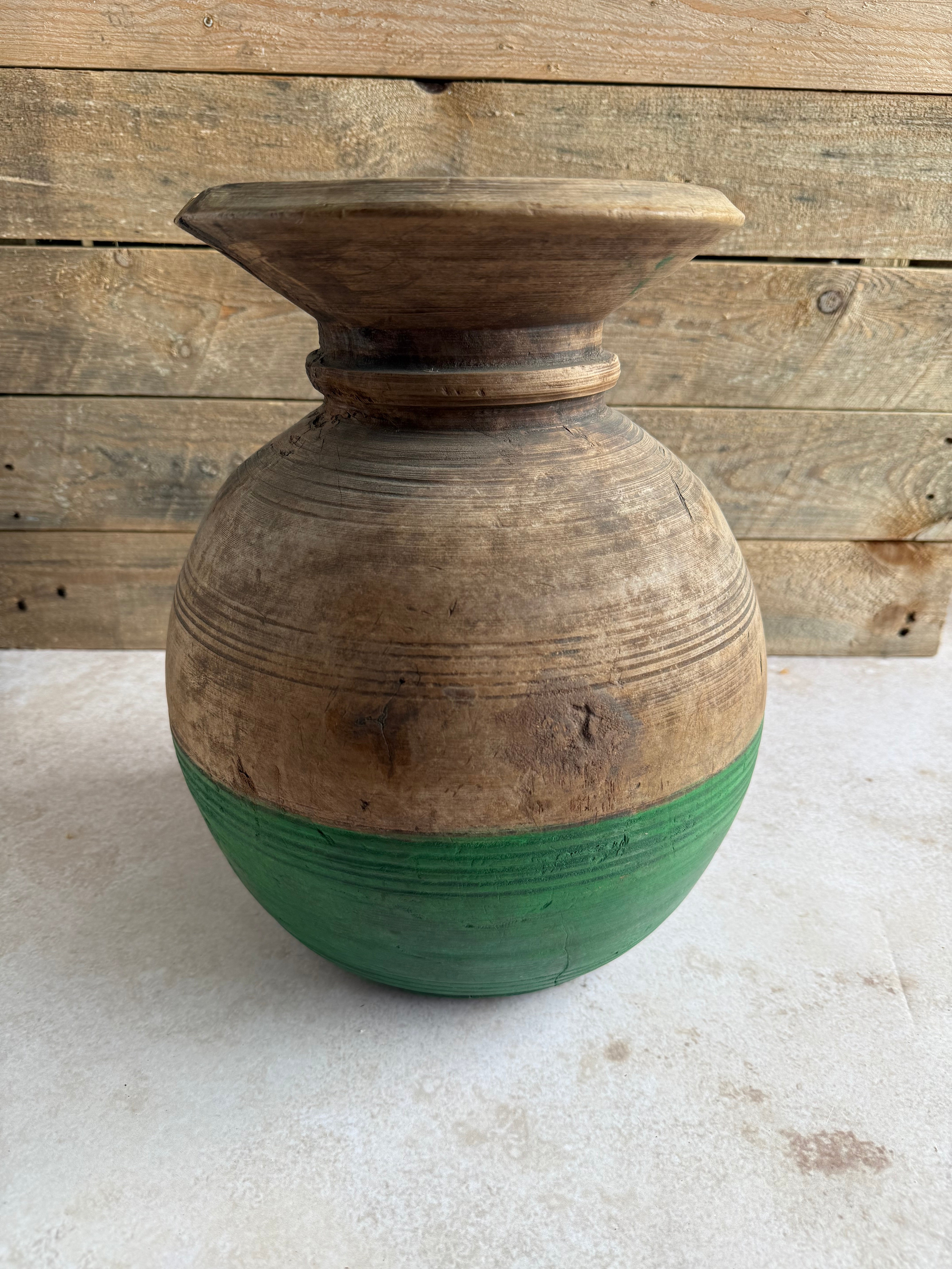 A traditional wooden neck pot with a green painted bottom, sourced in Western Nepal, intended for use as a decorative vase.