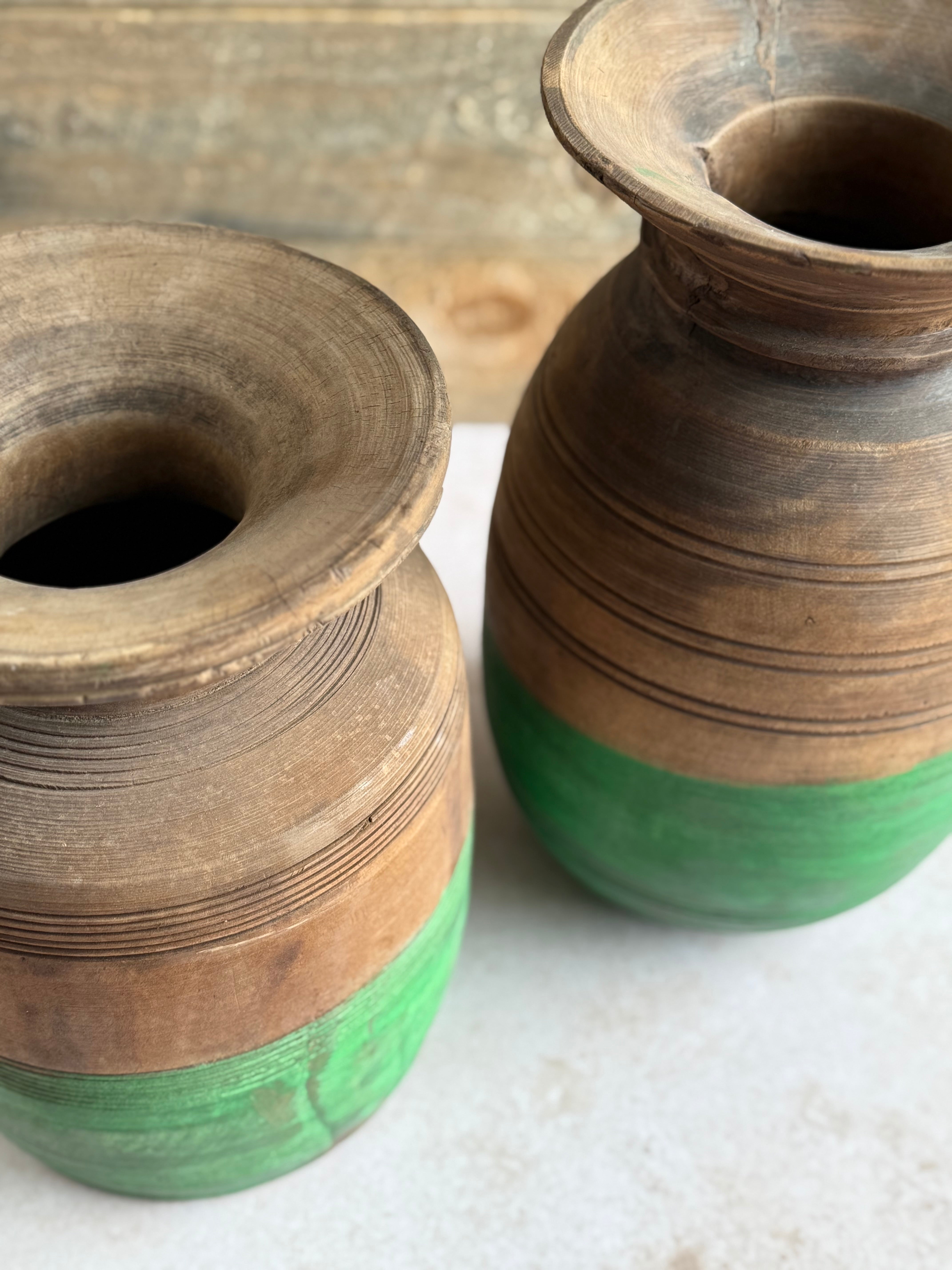 Two wooden vases with green base on white surface