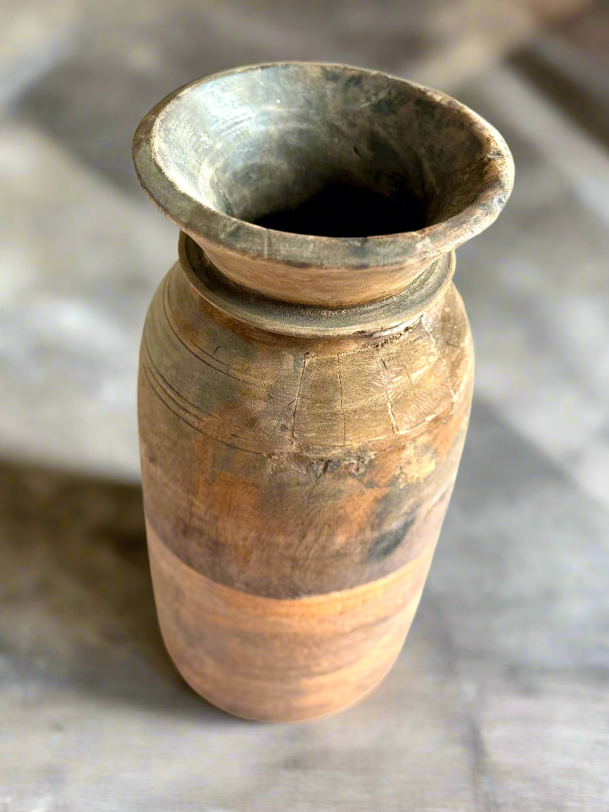 A vintage wooden milk pot with an apricot color, handpainted on the bottom, positioned upright on a wooden surface.