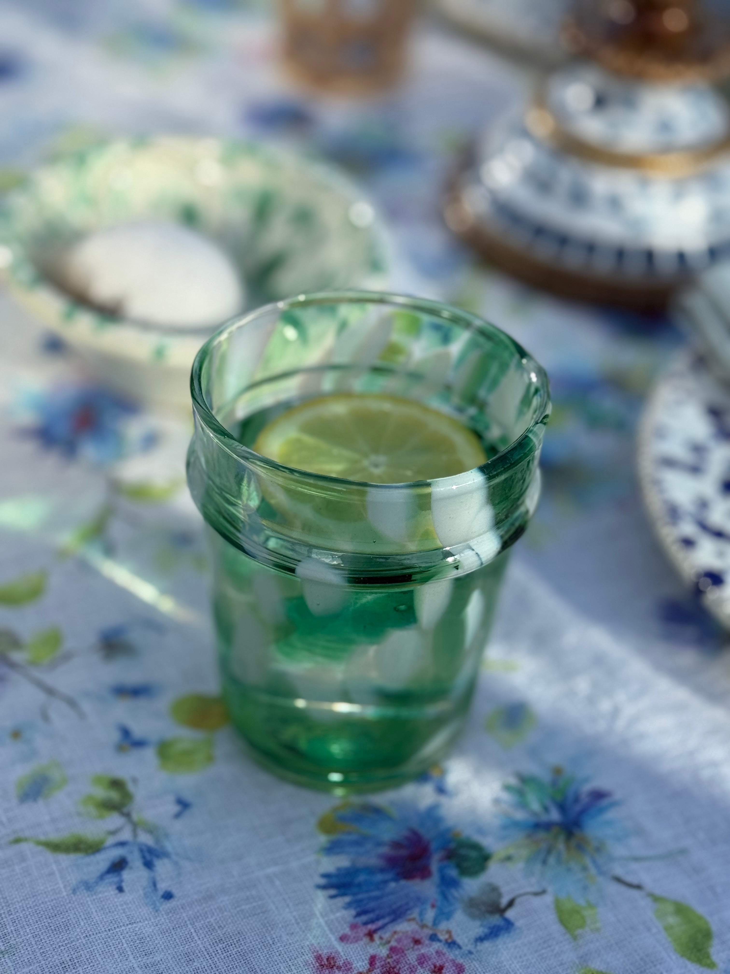 drinking glass with green and white splatter design
