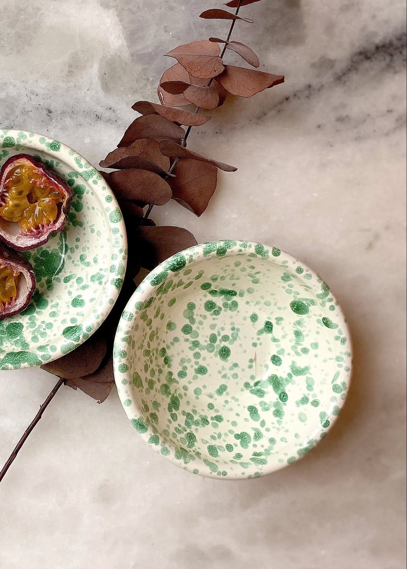 Overhead shot of green splatter mini bowls on white marble surface