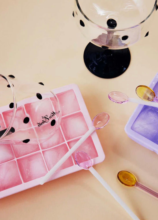 Overhead view of pink ice cube tray and glassware
