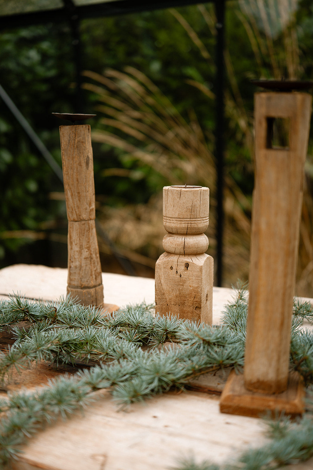 Reclaimed wood candlesticks in glass house setting
