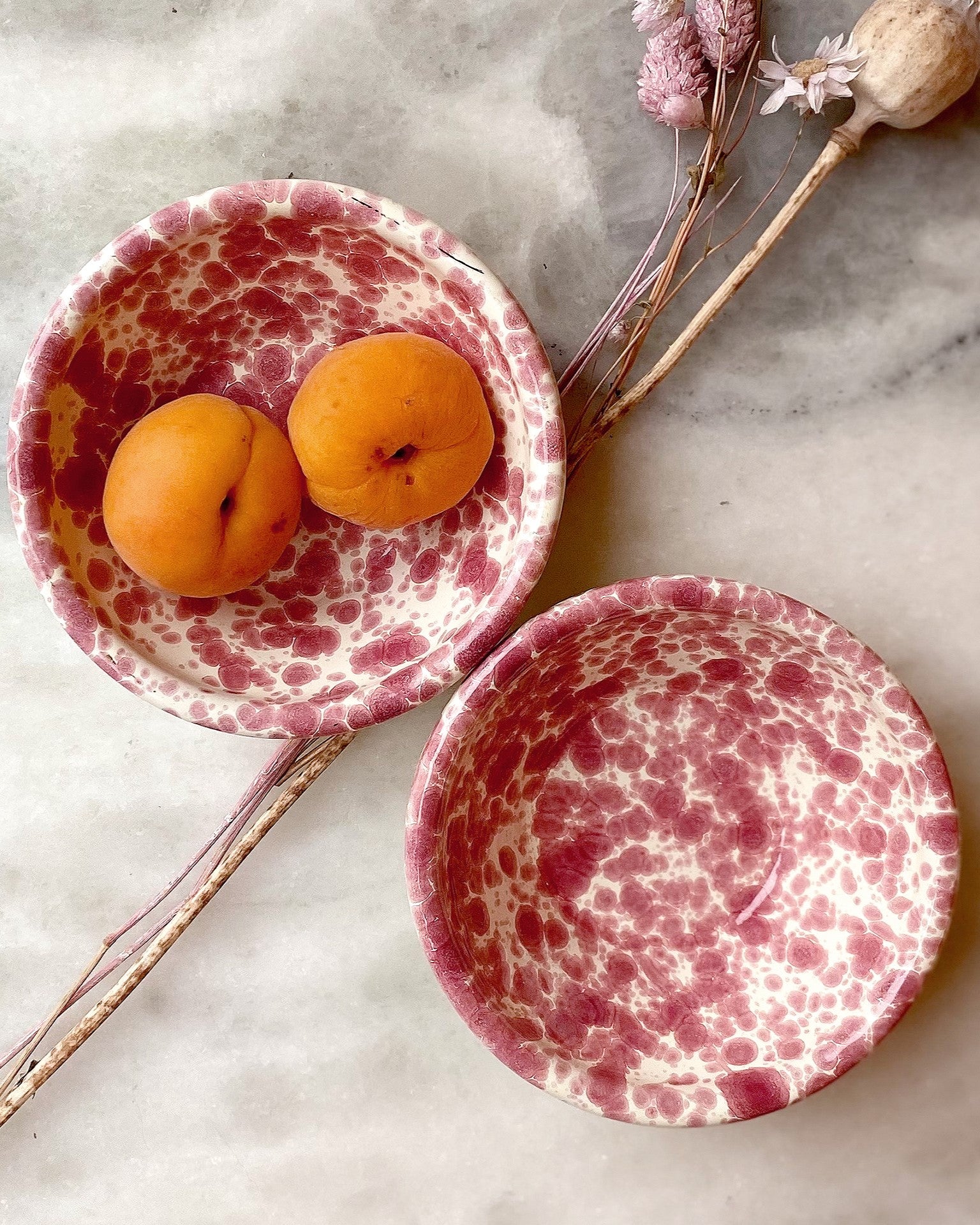 Overhead shot of red splatter mini bowls on white marble surface