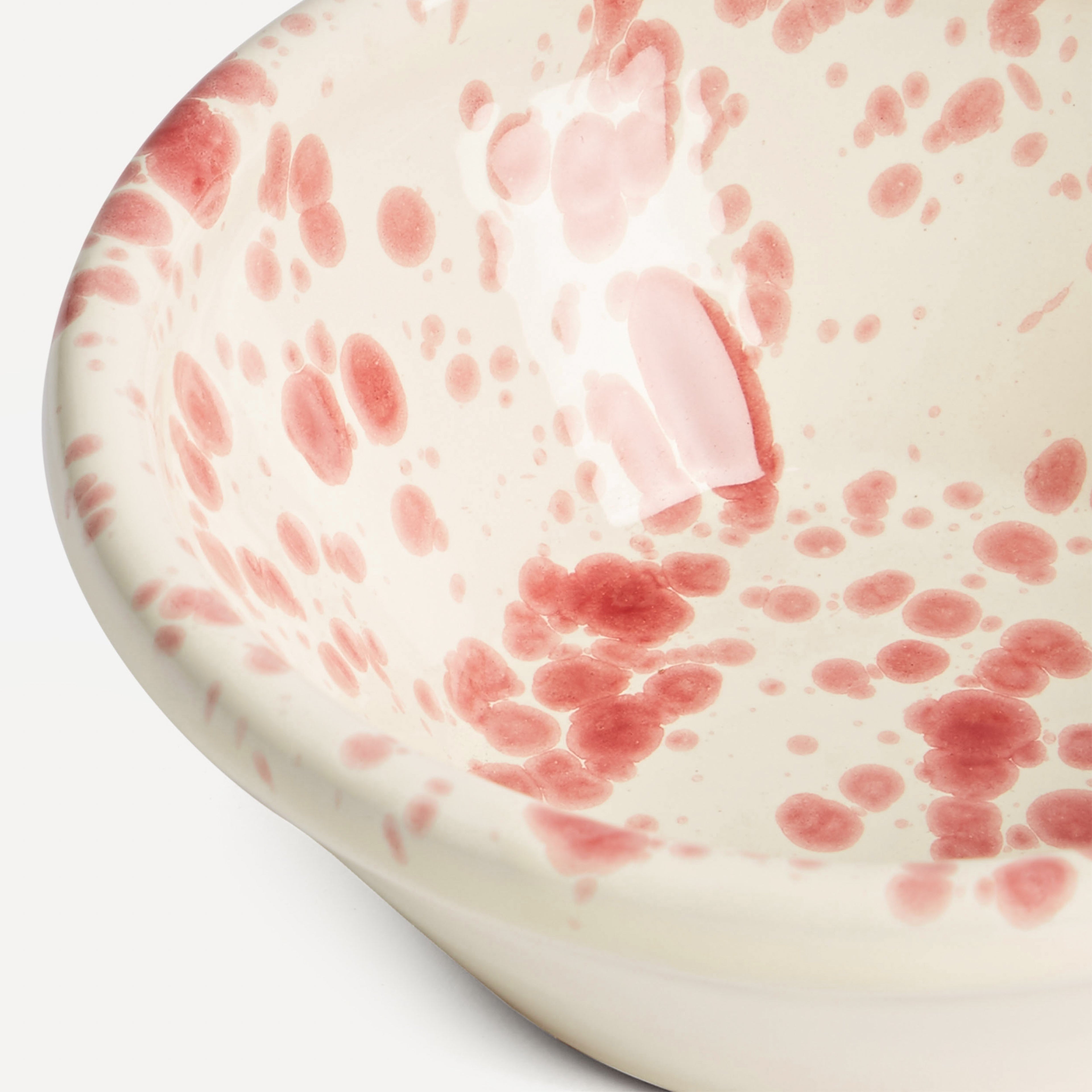 Close up detail shot of red splatter bowl on white baackground