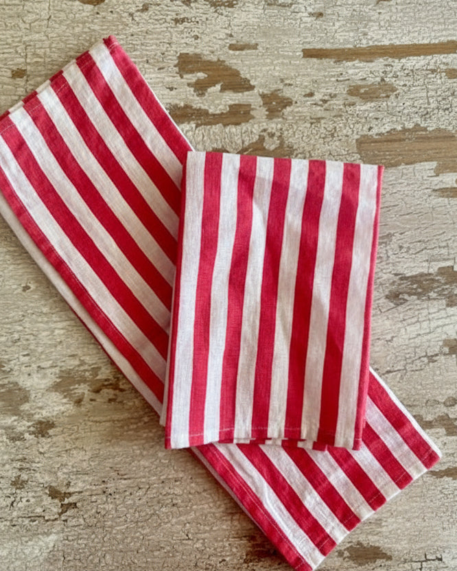 Red and white striped linen napkins folded on a textured surface