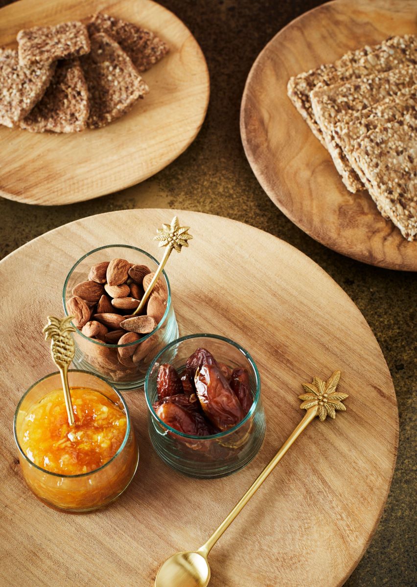 Overhead view of wood plates with fruits, chutneys and crackers 