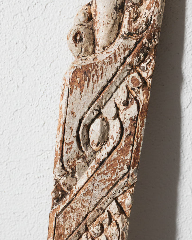 Decorative wooden panel with intricate carvings on a white background