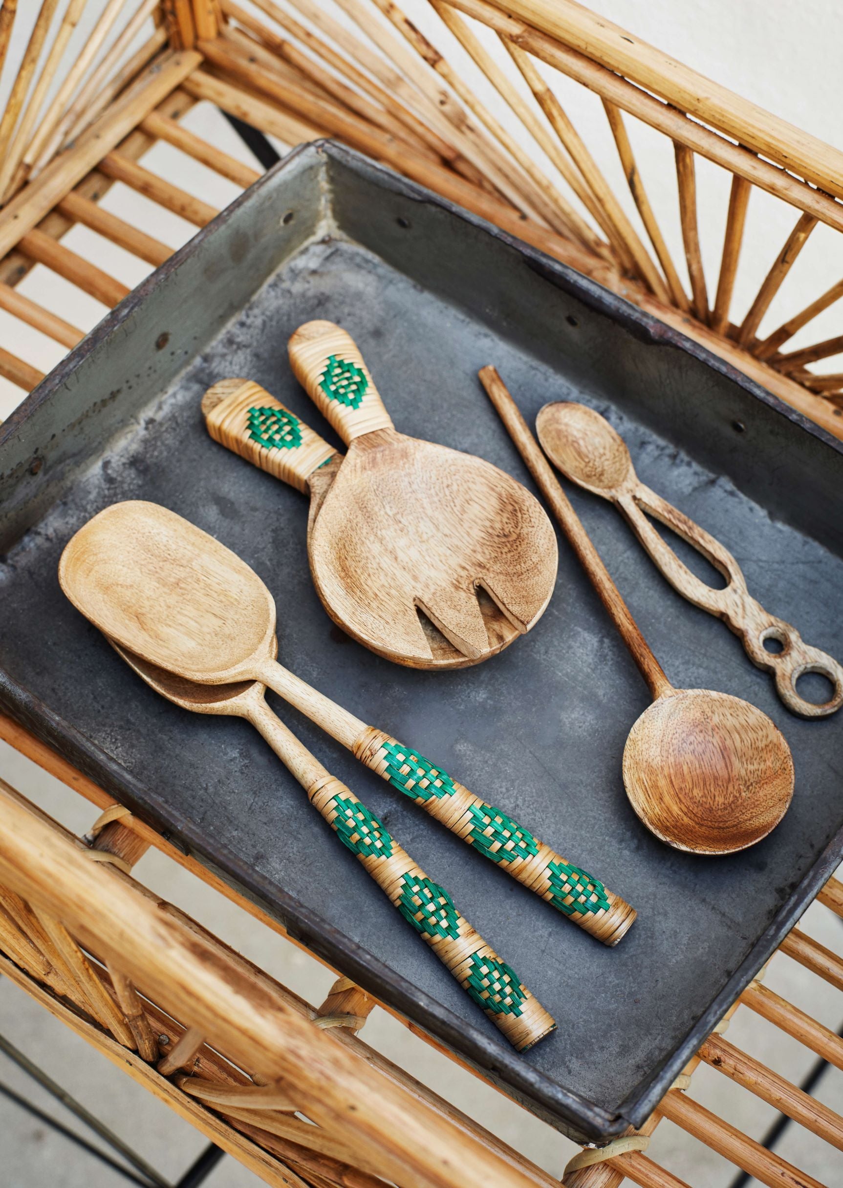 Bamboo utensils on slate tray on rattan surface