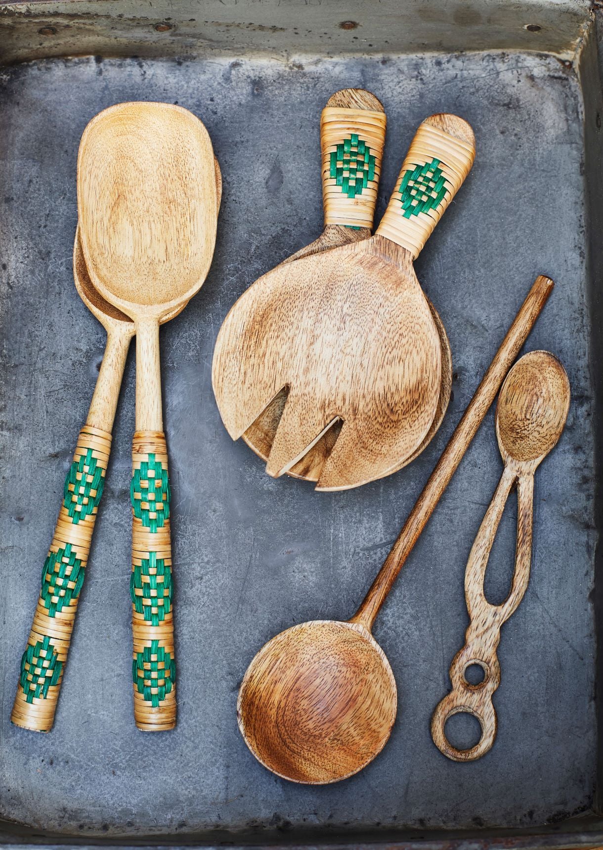 Overhead view of bamboo utensils on slate tray on rattan surface
