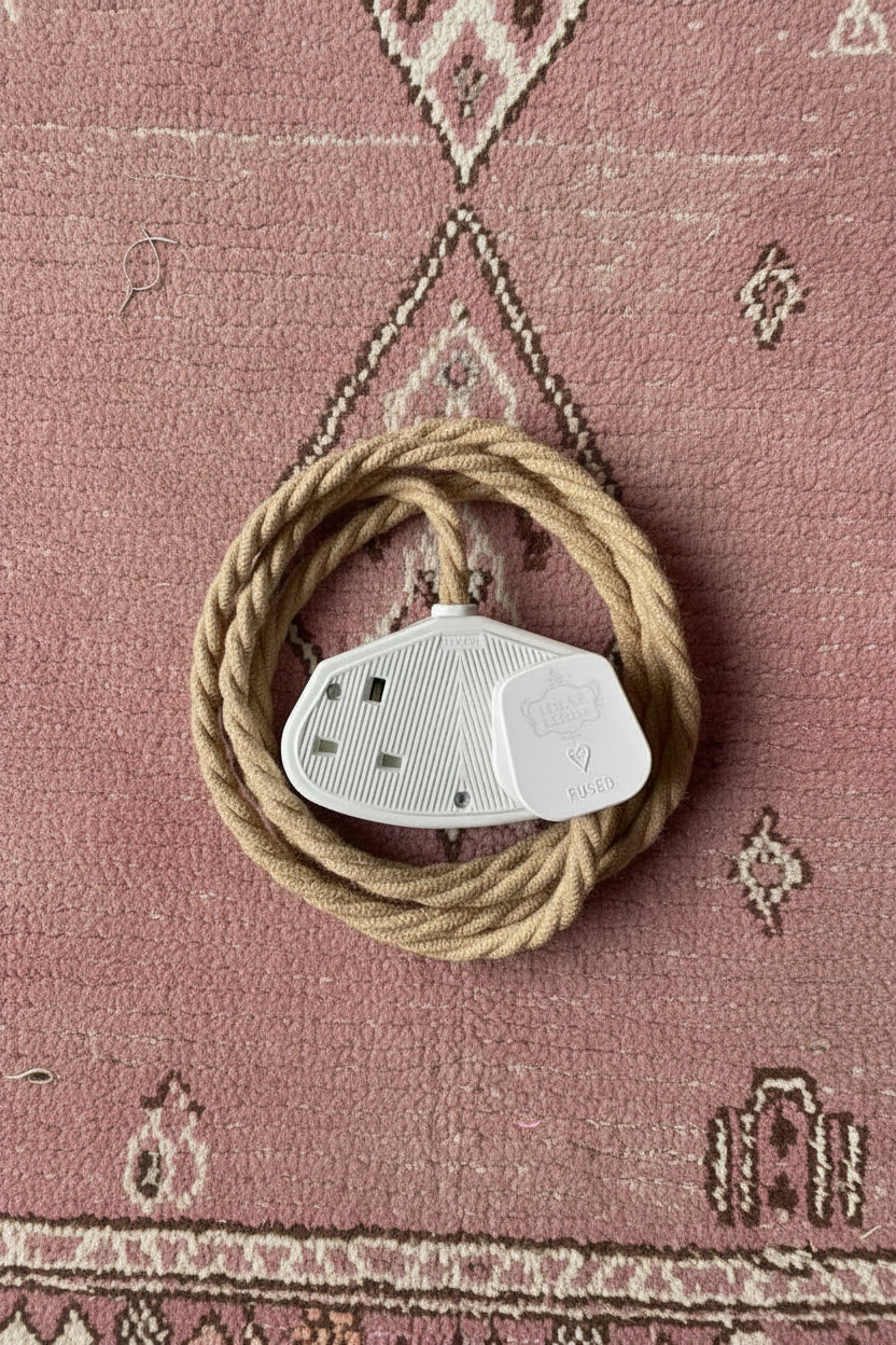 Vintage braided jute extension cable with double white socket laid on a vintage Moroccan rug